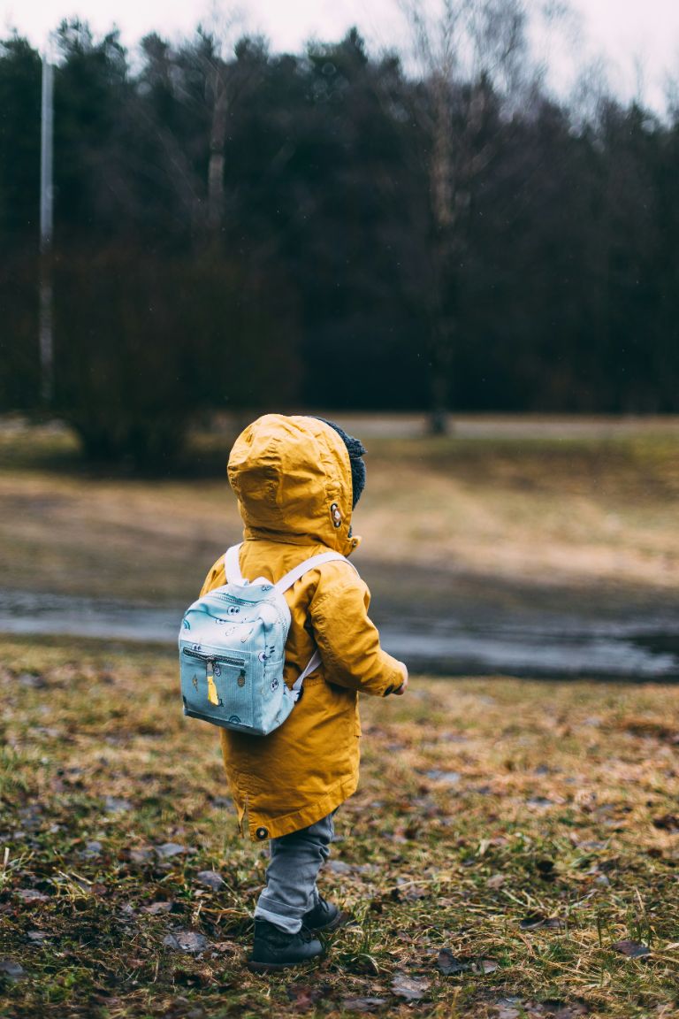 a toddler in a yellow rain jacket
